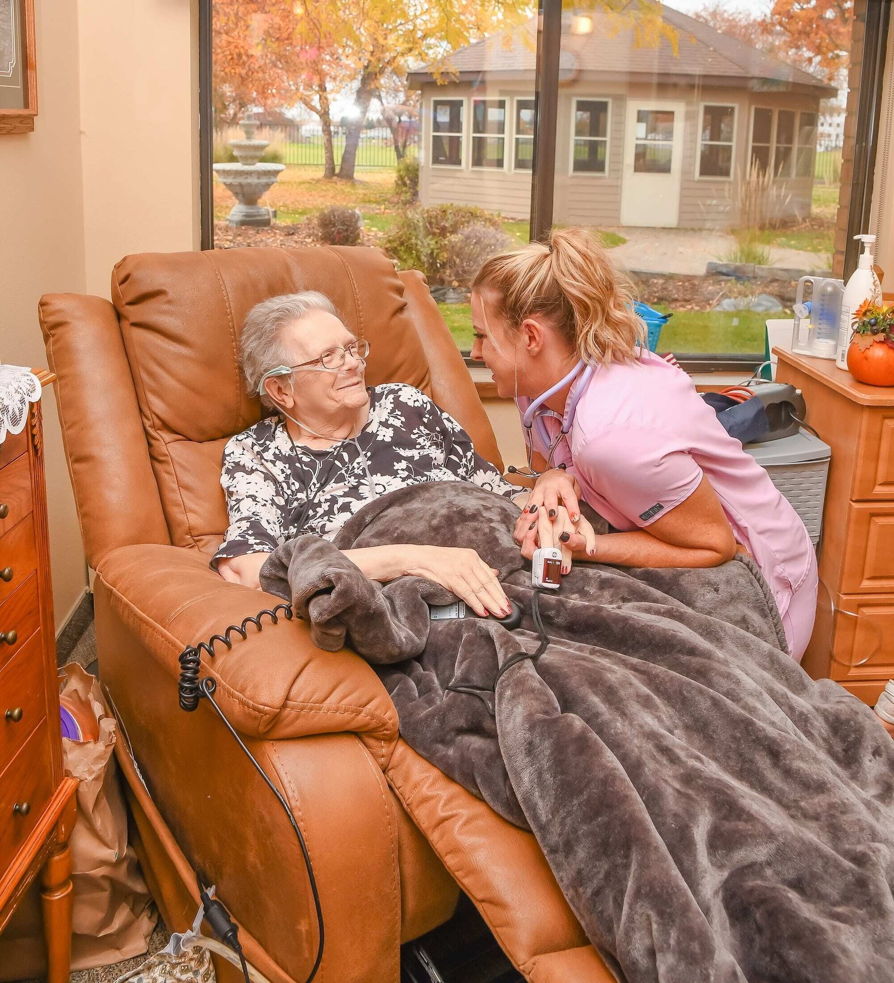 Photo of a nurse holding hand of woman in home healthcare