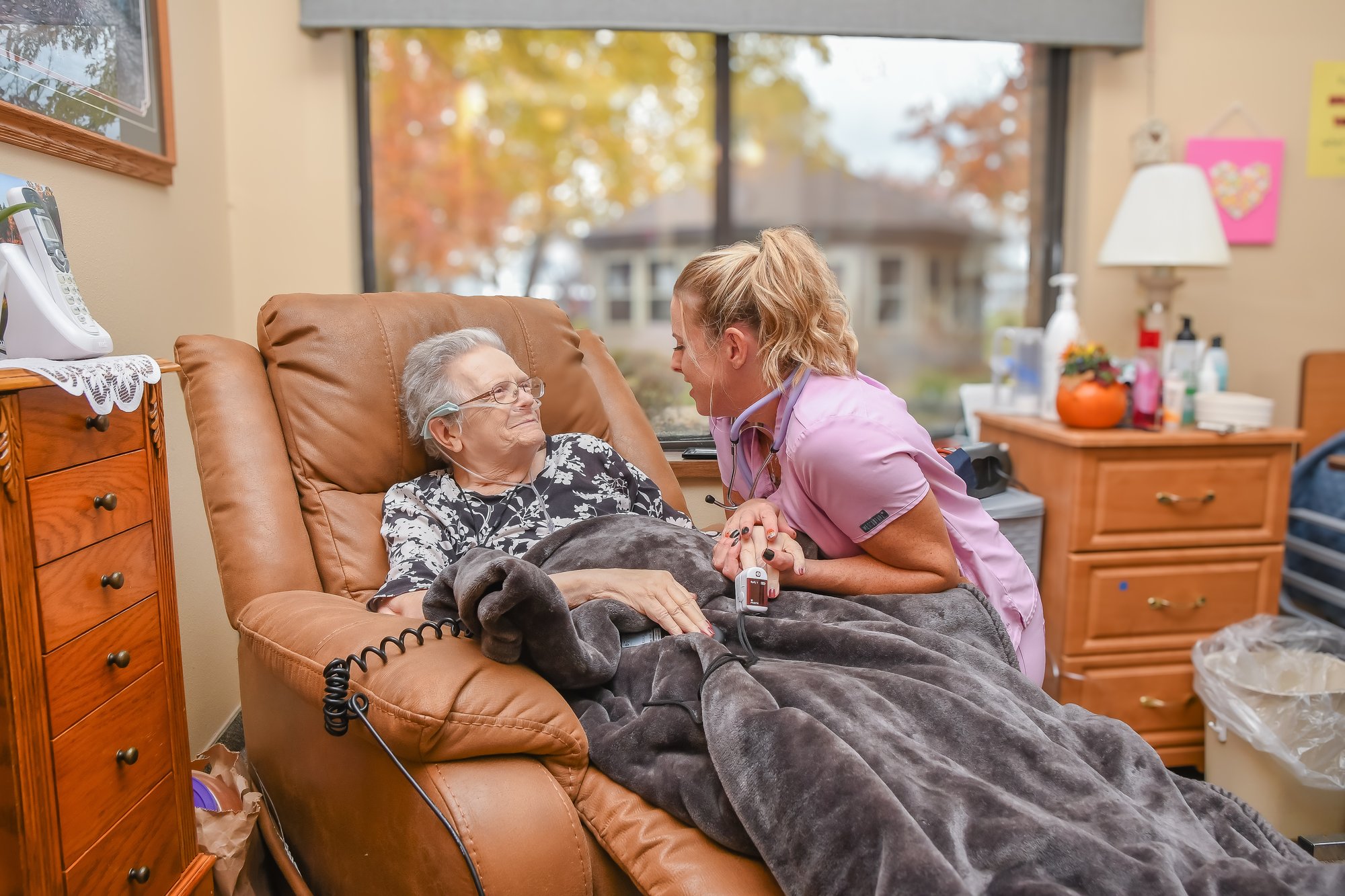 nurse holding hand of woman in home healthcare