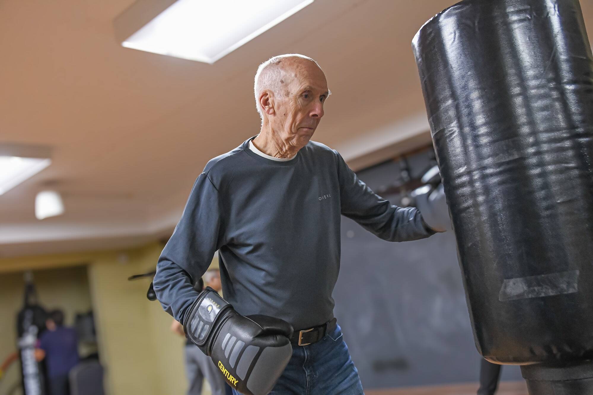 Photo of an older man in gray shirt boxing for PT