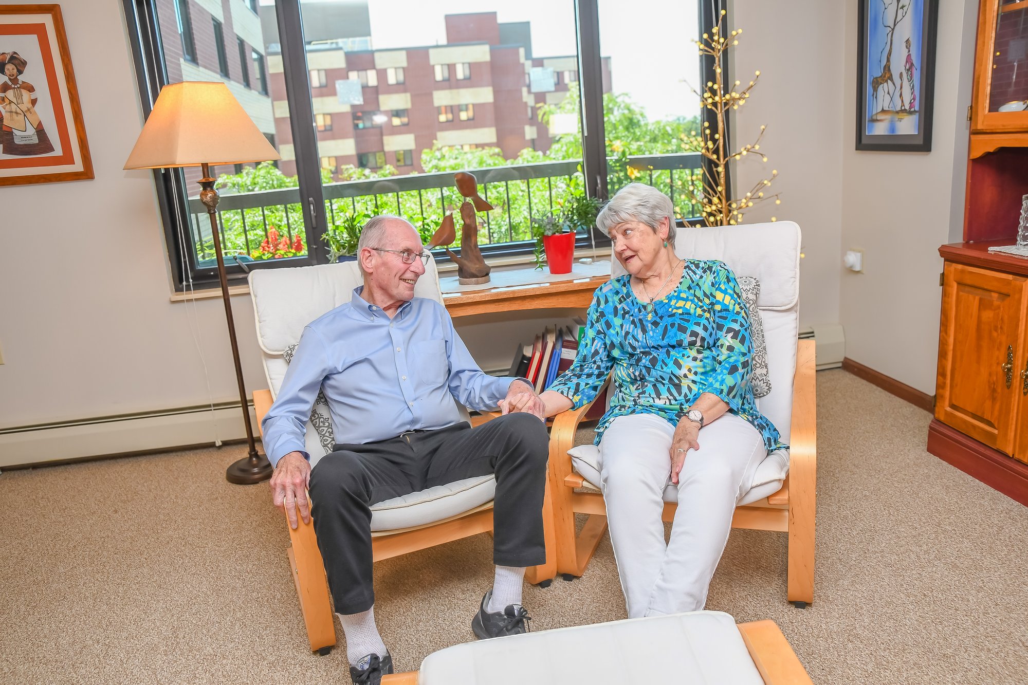 Older couple holding hands in senior living apartment