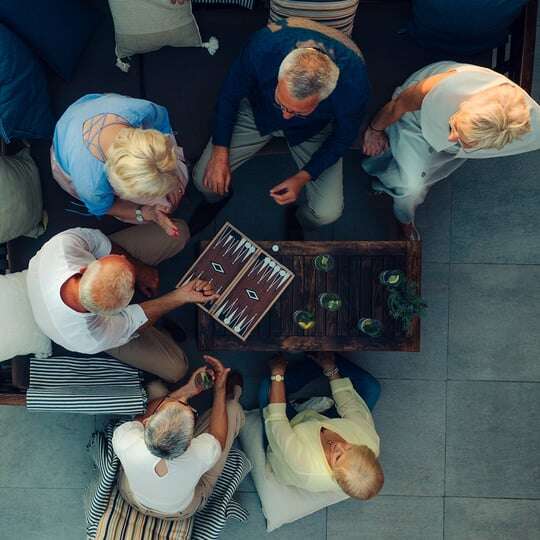 Top view of group of seniors playing game on patio