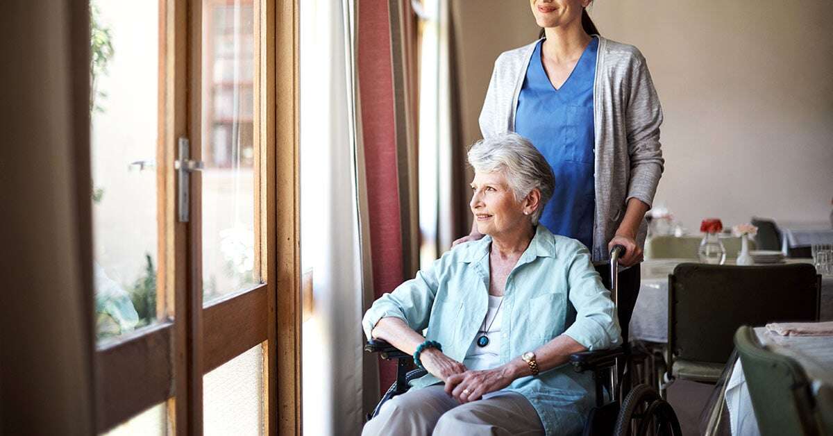 memory care nurse taking care of resident in wheelchair