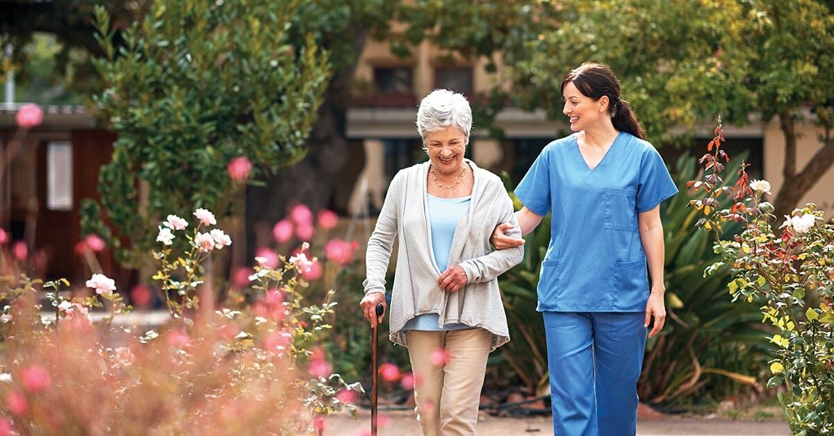 Senior woman walking with nurse