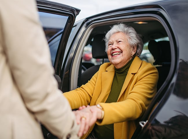 woman being helped out of car