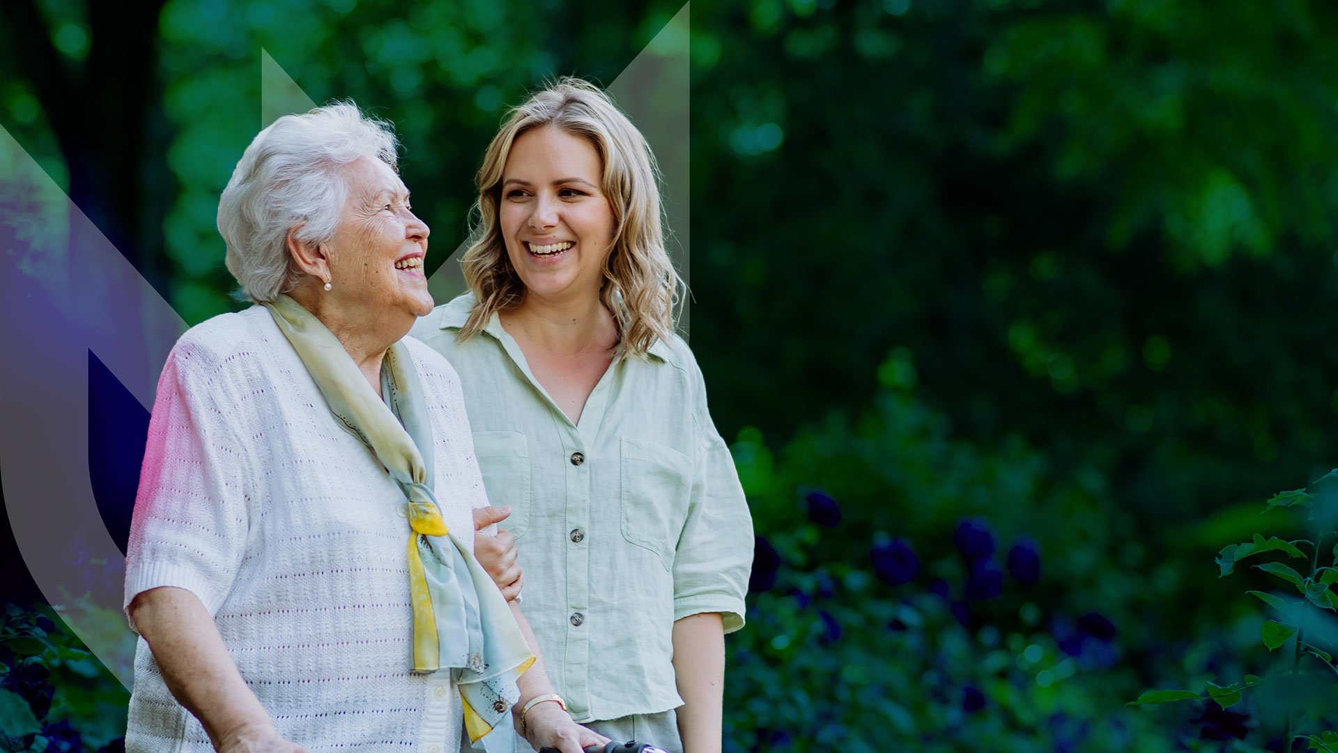 Photo of an older women smiling with a volunteer caregiver