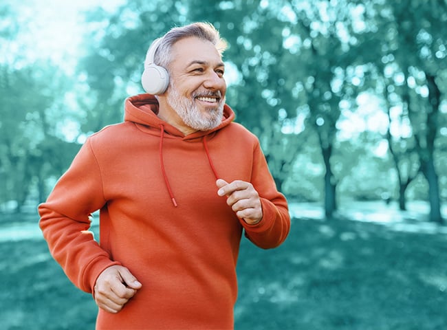 Photo of an older man in headphones jogging