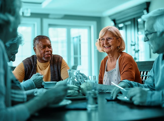 Photo of a group of people eating together in short term care community