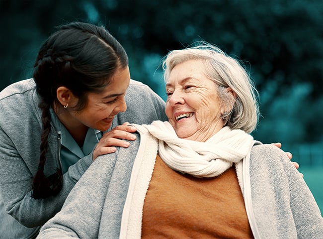 Photo of a long-term care nurse smiling and helping a resident