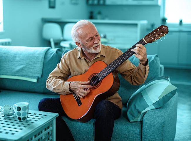 Photo of an older man playing guitar