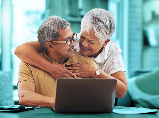 Photo of a woman hugging her husband as they search for senior living