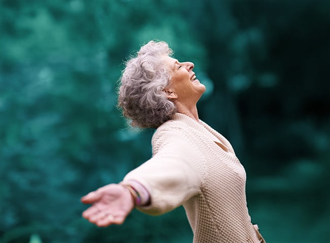Photo of a woman expressing wellness with arms wide open
