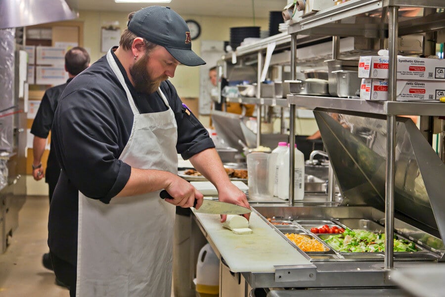 Photo of a line cook prepping a meal at the Pioneer Grill