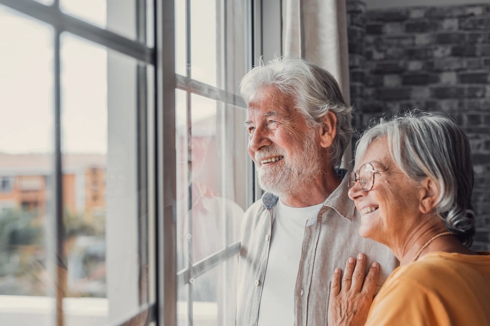 Photo of man and woman smiling out window