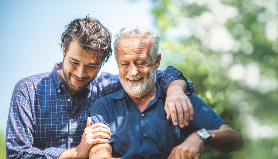 Photo of a male caretaker helping older man