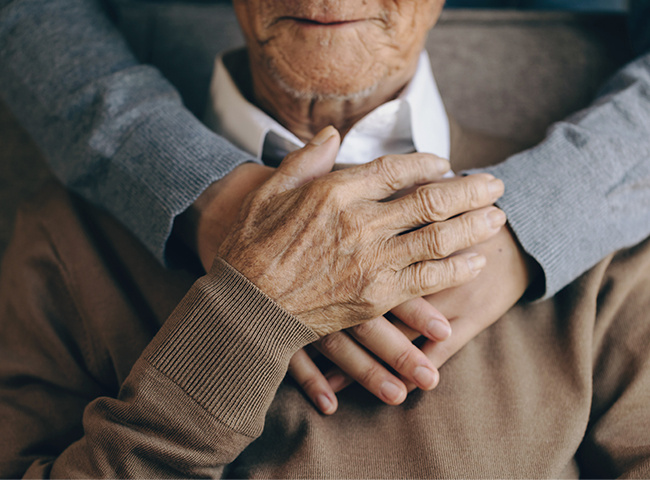 Photo of a respite caregiver hugging an elderly man