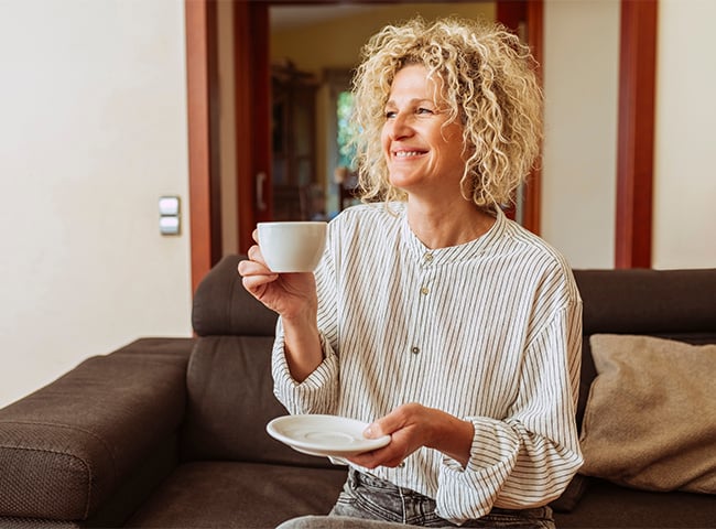 Photo of a woman enjoing a cup of coffee in longterm care
