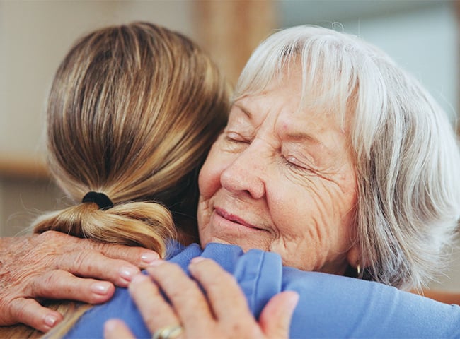 Photo of a woman hugging her assisted living nurse