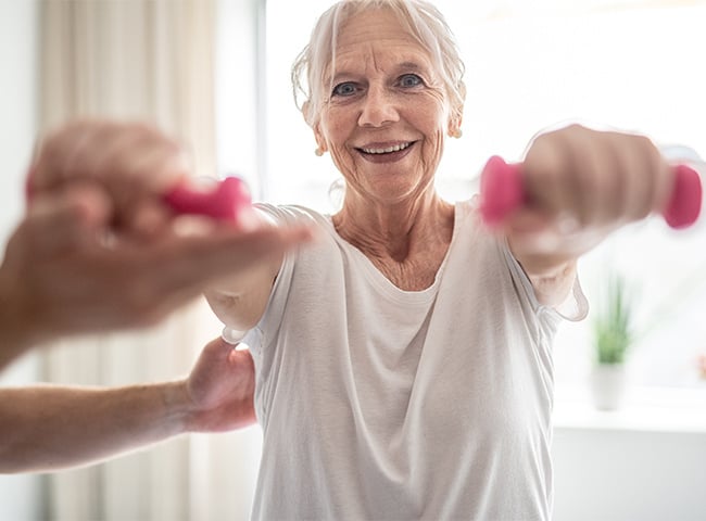 Photo of a woman lifting weights for PT