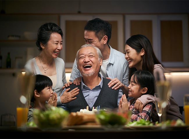 Photo of an older man laughing with family