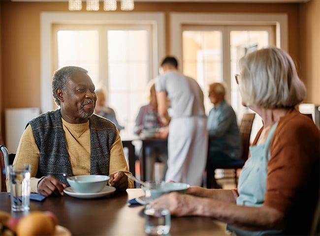 Photo of two older adults enjoying a meal in senior living