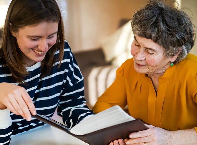 two women looking through book together
