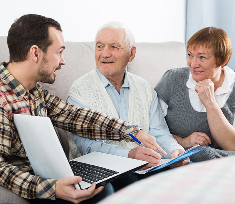 man with laptop sitting with elderly couple