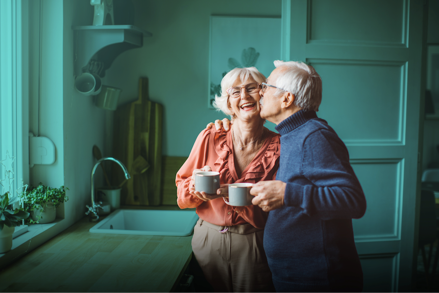 Photo of a senior couple kissing in their kitchen
