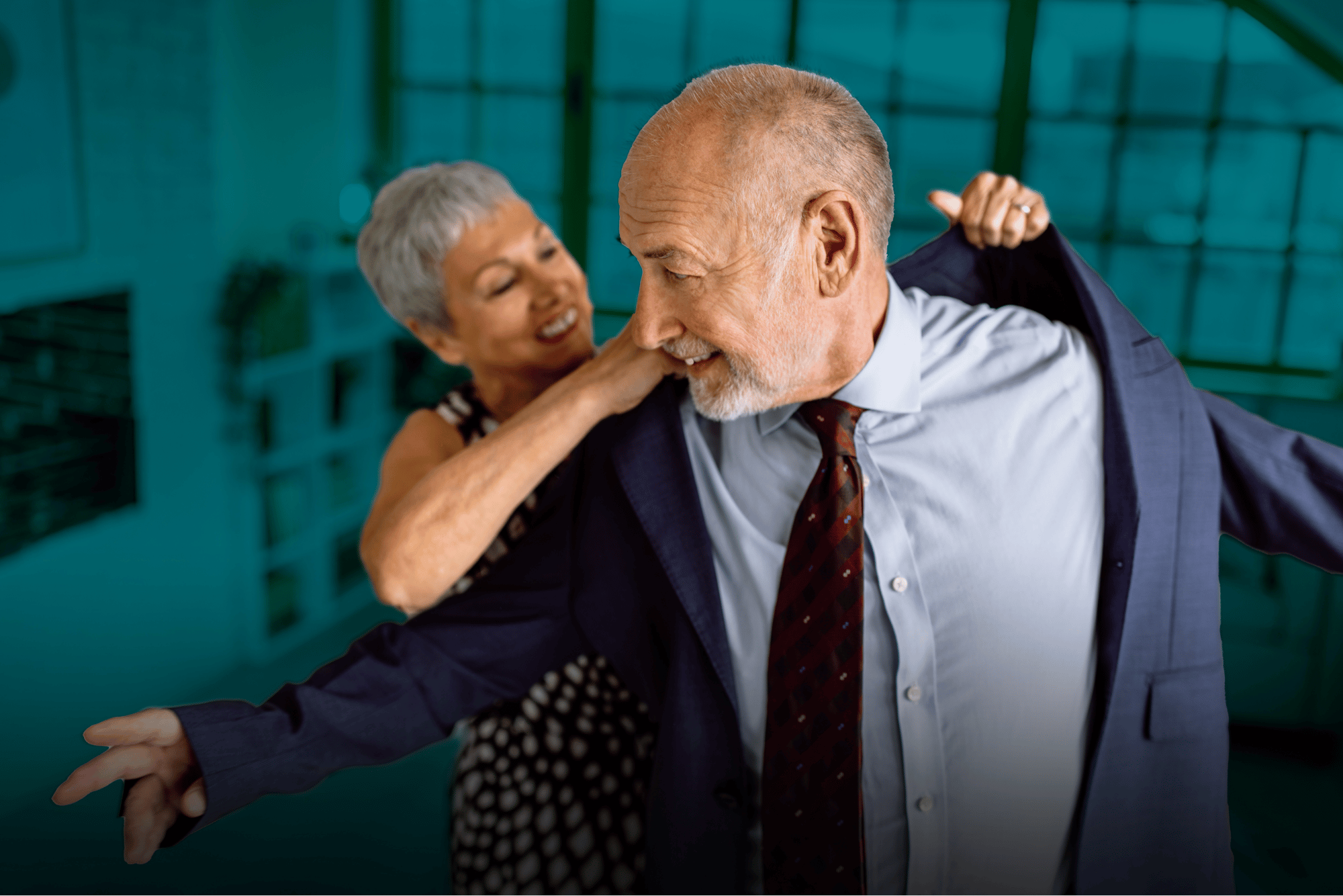 woman helping man put on suit jacket