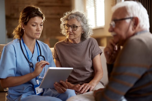 Hospice provider having a conversation with an adult couple.